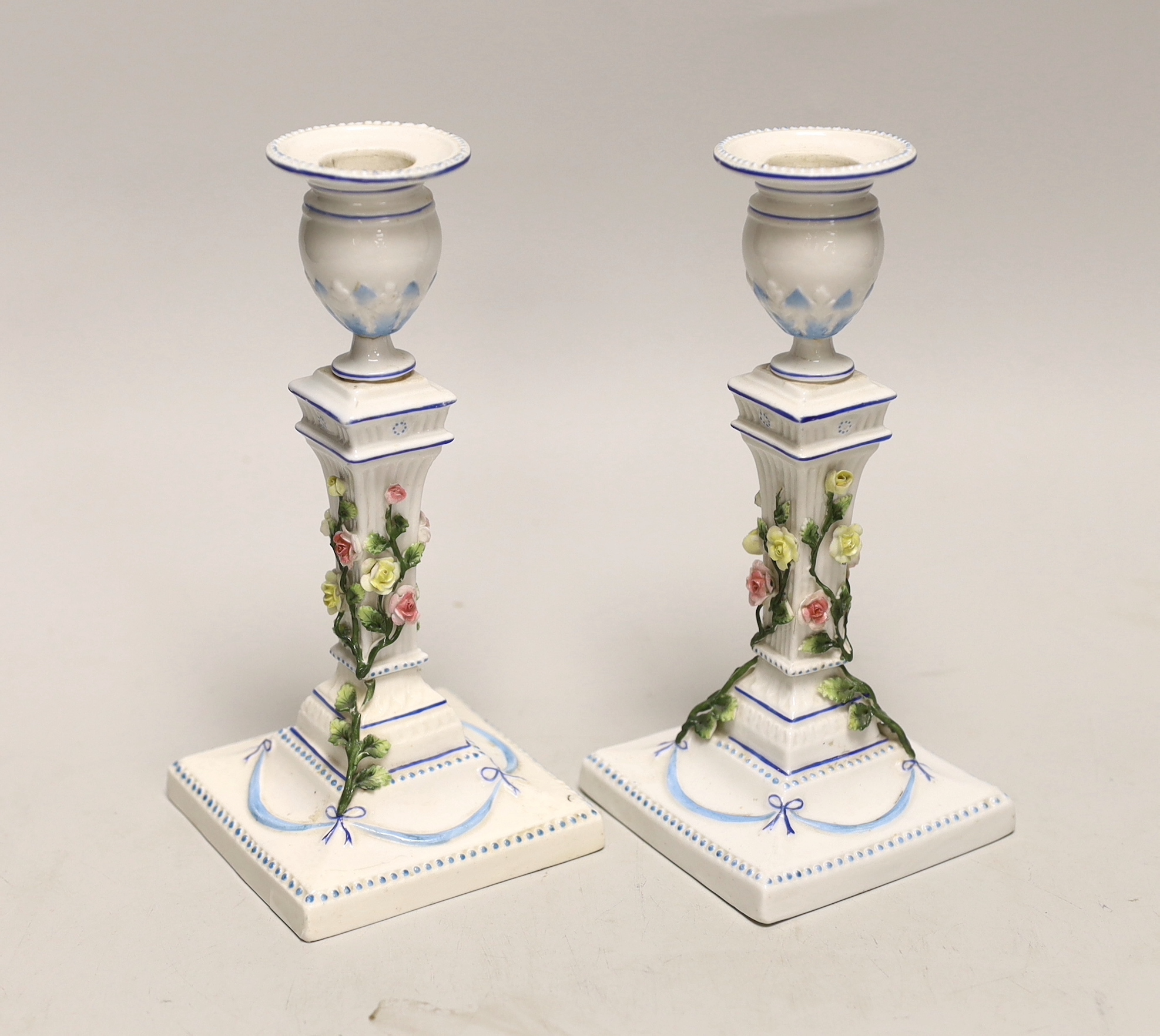 A pair of German porcelain candlesticks, marked JR, with applied floral decoration, 18cm